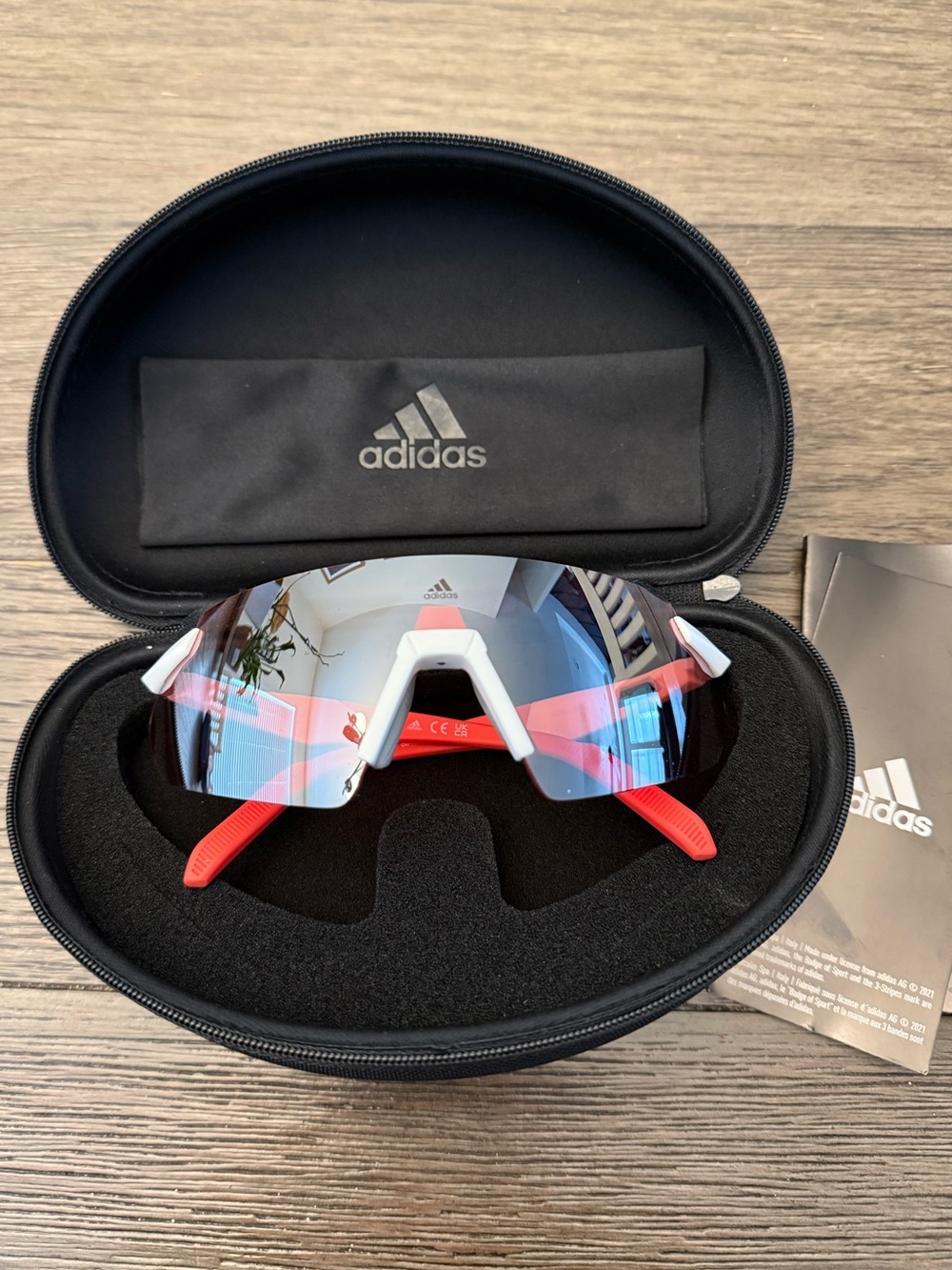 Adidas Sport SP0077 rimless shield sunglasses feature a white/red frames.